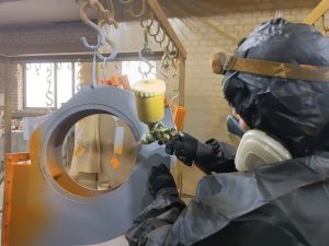 Специалисты ООО СКДЖИДИЭС проводят пескоструйную обработку и покраску крупного промышленного оборудования.